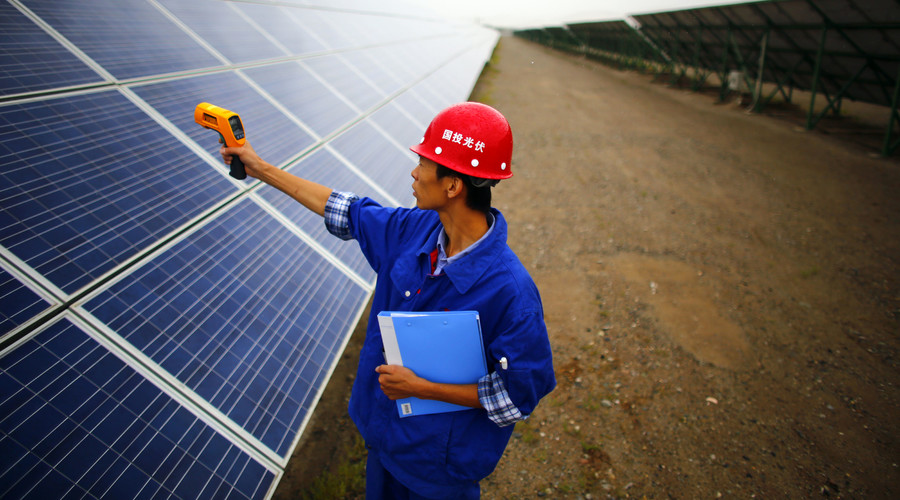 A worker inspects solar panels at a solar farm in Dunhuang, 950km (590 miles) northwest of Lanzhou, Gansu Province. © Carlos Barria 